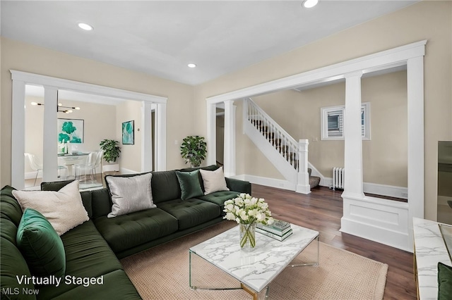 living room with radiator heating unit, dark wood finished floors, stairs, and recessed lighting