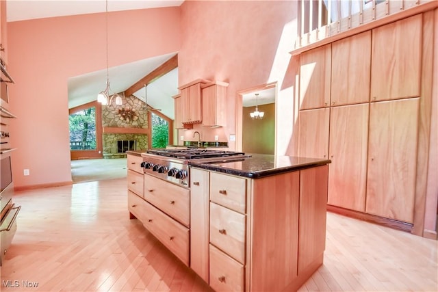 8220 Hermitage Rd, Concord, OH 44077 - kitchen featuring light brown cabinetry, a chandelier, stainless steel gas cooktop, high vaulted ceiling, and a stone fireplace