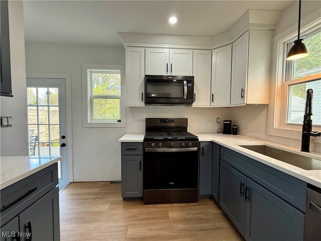 kitchen featuring range with gas stovetop, a sink, gray cabinets, plenty of natural light, and recessed lighting