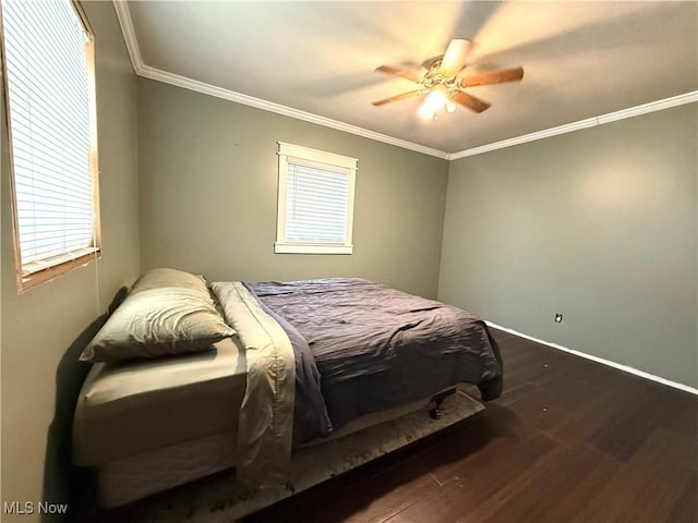 bedroom with dark wood-type flooring, ornamental molding, baseboards, a ceiling fan, and multiple windows