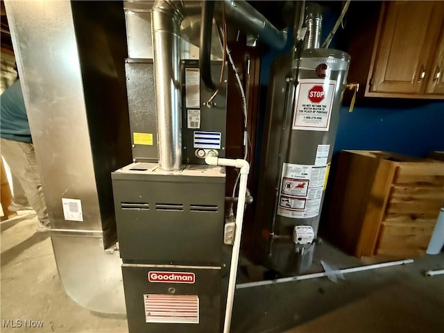 utility room featuring heating unit and gas water heater