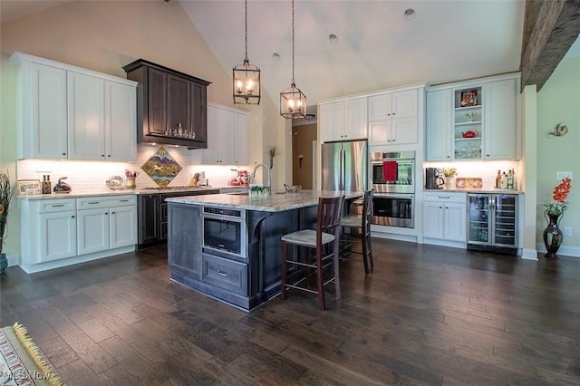 176 Highland Mist Cir, Hinckley, OH 44233 - kitchen featuring wine cooler, appliances with stainless steel finishes, a kitchen bar, tasteful backsplash, and dark wood-type flooring