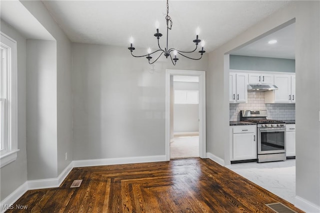 406 39th St, Vienna, WV 26105 - kitchen featuring stainless steel range with gas stovetop, under cabinet range hood, a chandelier, dark countertops, and baseboards