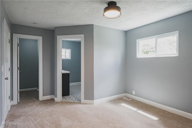 406 39th St, Vienna, WV 26105 - unfurnished bedroom featuring multiple windows, light colored carpet, baseboards, and a textured ceiling