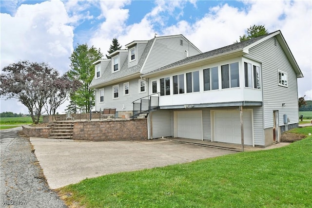 9960 Ridge Rdg, Farmdale, OH 44417 - rear view of property with an attached garage, driveway, and a lawn