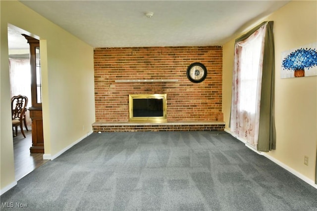 9960 Ridge Rdg, Farmdale, OH 44417 - unfurnished living room with carpet, a fireplace, baseboards, and brick wall
