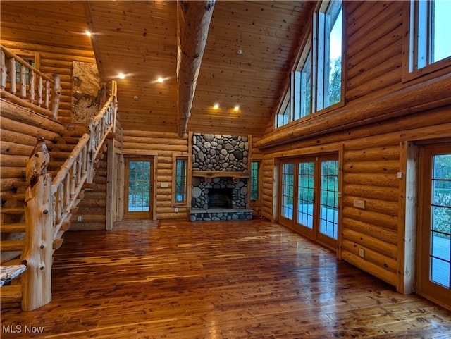 5216 Arrow Rd NW, Minerva, OH 44657 - unfurnished living room featuring high vaulted ceiling, wood finished floors, log walls, stairway, and a fireplace