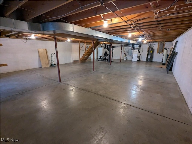unfinished below grade area featuring water heater and stairs