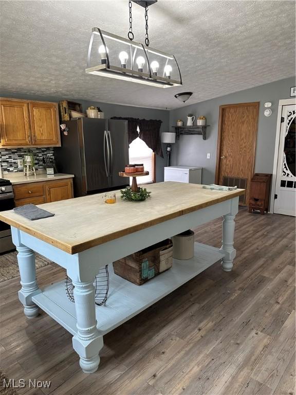 1367 Arner Rd, Chester, WV 26034 - kitchen with freestanding refrigerator, butcher block counters, a textured ceiling, brown cabinets, and electric stove