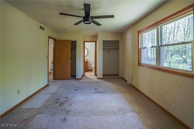 265 Franklin Dr, Doylestown, OH 44230 - unfurnished bedroom with light carpet, baseboards, connected bathroom, and multiple closets