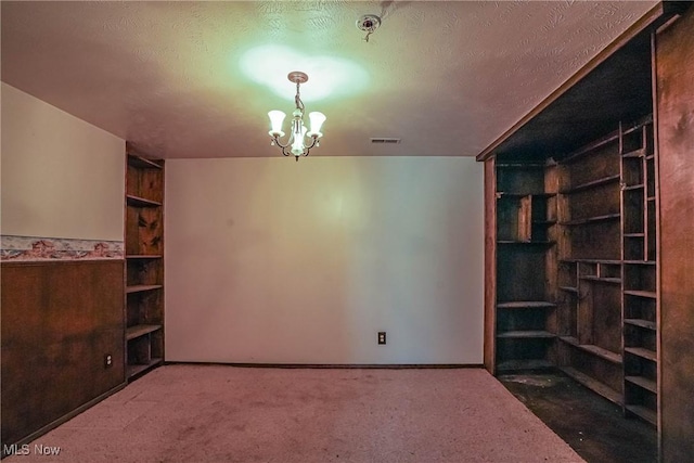 265 Franklin Dr, Doylestown, OH 44230 - interior space featuring built in features, carpet flooring, a chandelier, a textured ceiling, and baseboards