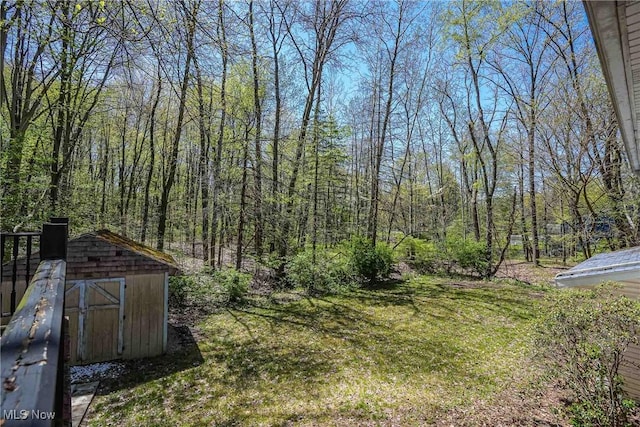 265 Franklin Dr, Doylestown, OH 44230 - view of green lawn featuring a storage unit, an outbuilding, and a wooded view