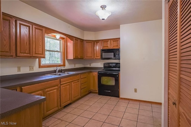 265 Franklin Dr, Doylestown, OH 44230 - kitchen with black appliances, a sink, dark countertops, light tile patterned floors, and brown cabinets