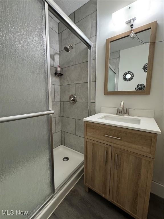 5897 Kimberly Dr, Bedford Heights, OH 44146 - full bathroom with a stall shower, vanity, and wood finished floors