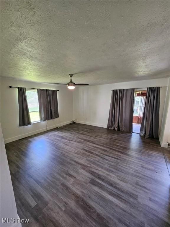 5897 Kimberly Dr, Bedford Heights, OH 44146 - spare room featuring a textured ceiling, healthy amount of natural light, dark wood-style flooring, and a ceiling fan