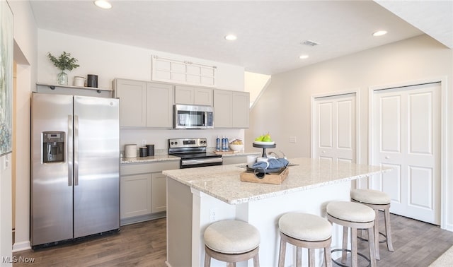 424 Honeycrisp Dr NE, Louisville, OH 44641 - kitchen with appliances with stainless steel finishes, gray cabinets, dark wood finished floors, a kitchen breakfast bar, and recessed lighting