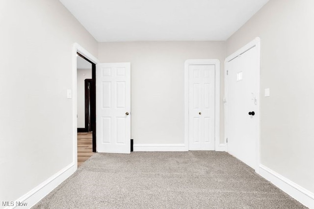 unfurnished bedroom with carpet flooring, baseboards, and a closet