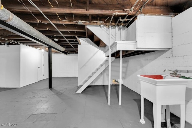 unfinished below grade area featuring stairs and a sink