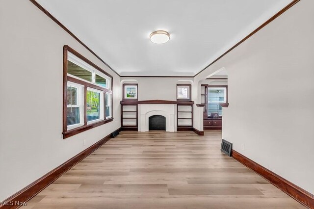 unfurnished living room featuring baseboards, light wood-type flooring, and a fireplace