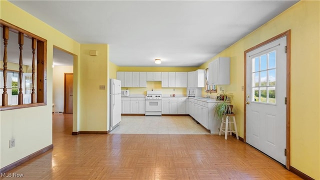 7116 Norwalk Rd, Medina, OH 44256 - kitchen with white appliances, baseboards, white cabinets, light countertops, and a sink