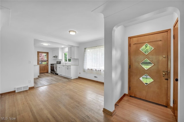 4422 Forest Hills Blvd, Parma, OH 44134 - foyer with light wood-style flooring, baseboards, and arched walkways