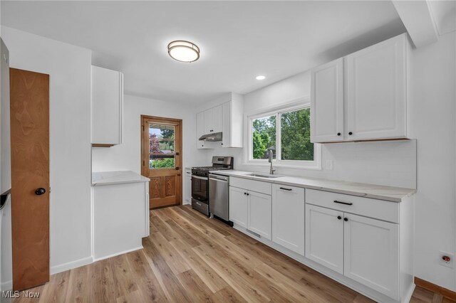 4422 Forest Hills Blvd, Parma, OH 44134 - kitchen featuring stainless steel appliances, a sink, light wood-style flooring, under cabinet range hood, and white cabinets