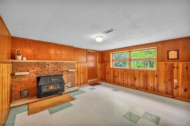 4422 Forest Hills Blvd, Parma, OH 44134 - unfurnished living room with wooden walls, tile patterned floors, and a wood stove