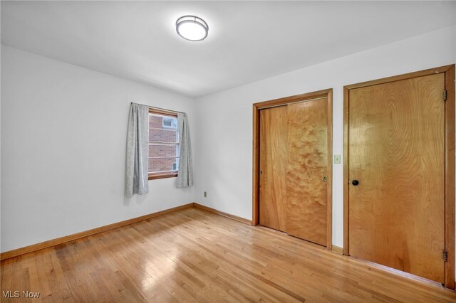4422 Forest Hills Blvd, Parma, OH 44134 - unfurnished bedroom featuring light wood-style floors, baseboards, and multiple closets