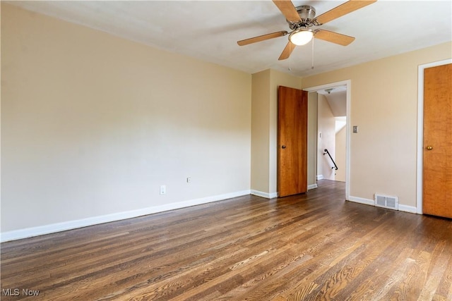 empty room with dark wood finished floors, baseboards, and ceiling fan