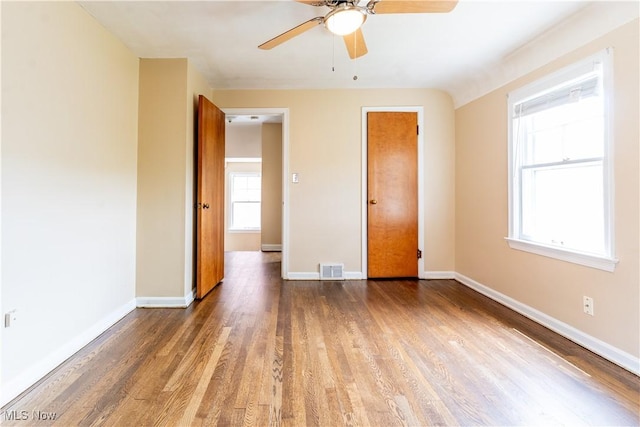 unfurnished bedroom featuring wood finished floors, baseboards, and ceiling fan