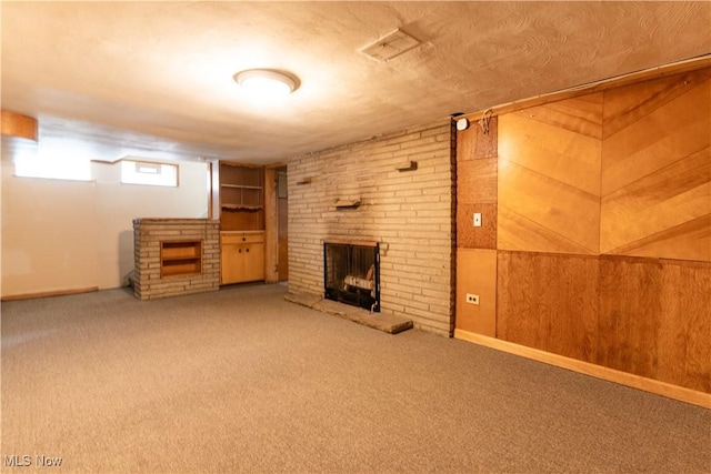 basement with a brick fireplace and carpet