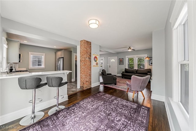 1303 W 115th St, Cleveland, OH 44102 - living room with dark wood-type flooring, ceiling fan, ornate columns, and baseboards