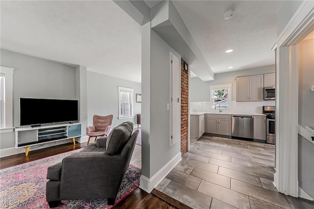 1303 W 115th St, Cleveland, OH 44102 - kitchen featuring stainless steel appliances, gray cabinets, a sink, open floor plan, and light countertops