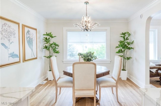 2332 Allison Rd, University Heights, OH 44118 - dining space with arched walkways, light wood-style flooring, a chandelier, ornamental molding, and baseboards