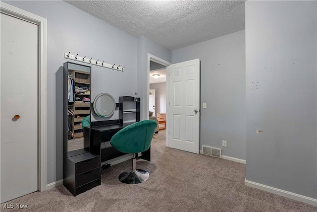 office area with a textured ceiling, carpet flooring, and baseboards