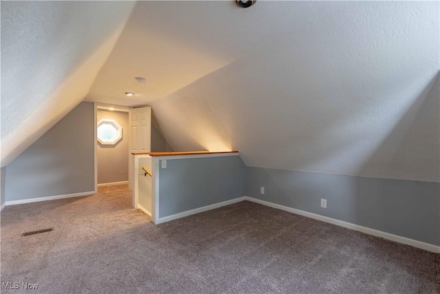 additional living space with carpet floors, vaulted ceiling, and baseboards