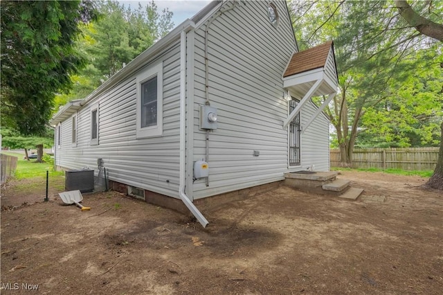 view of home's exterior featuring fence and cooling unit
