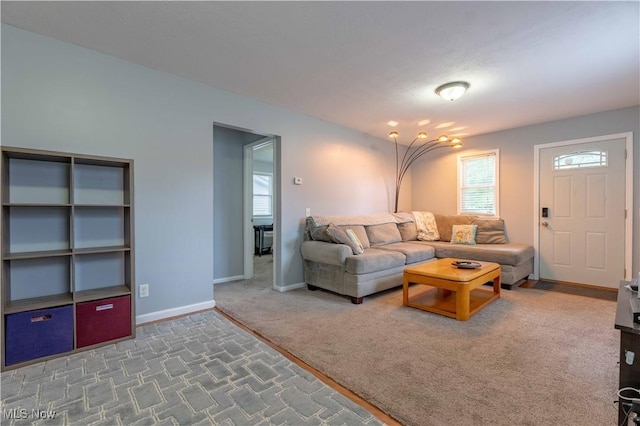 carpeted living area with baseboards