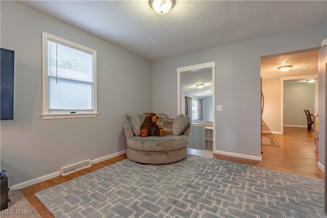 sitting room with baseboards and wood finished floors