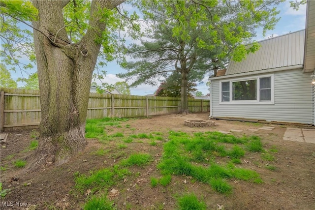 fenced backyard with an outdoor fire pit