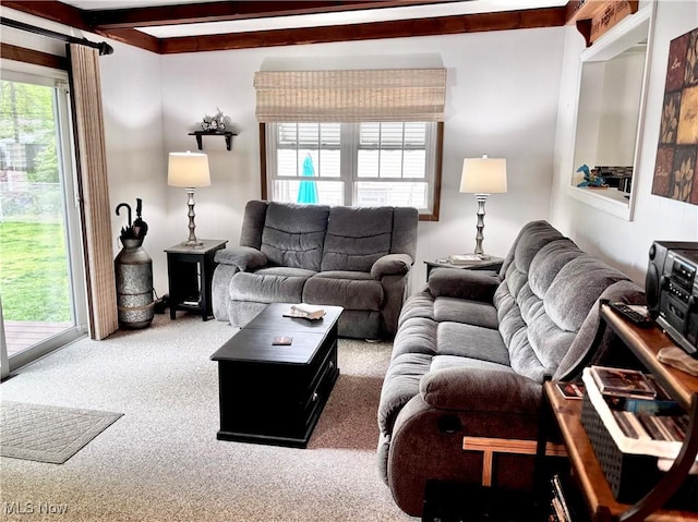 carpeted living room with beamed ceiling
