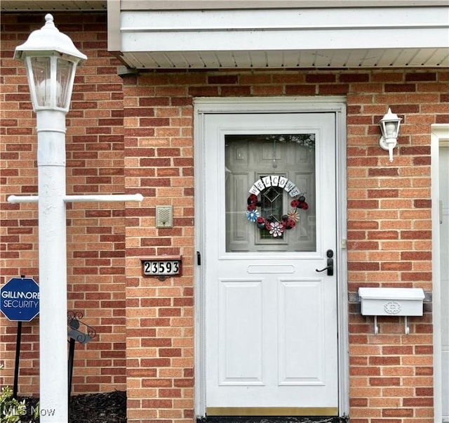 entrance to property featuring brick siding