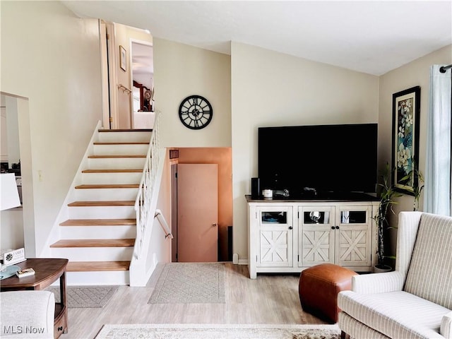 living room with wood finished floors and stairs