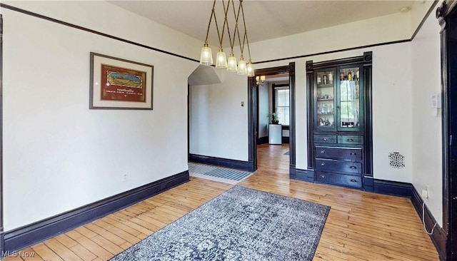 2963 Scranton Rd, Cleveland, OH 44113 - unfurnished dining area with hardwood / wood-style flooring, baseboards, and arched walkways