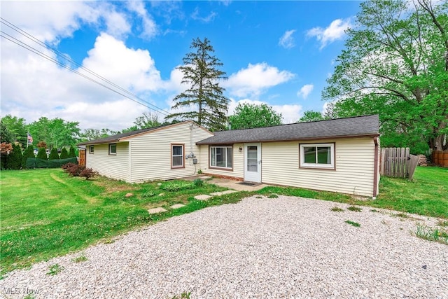 rear view of property featuring gravel driveway