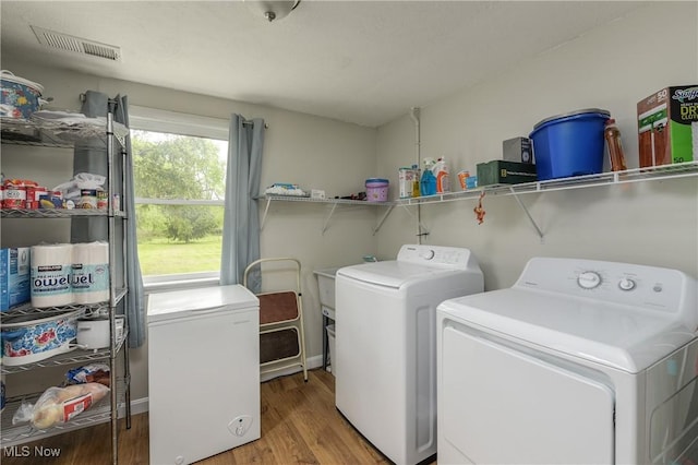 laundry room with independent washer and dryer and wood finished floors