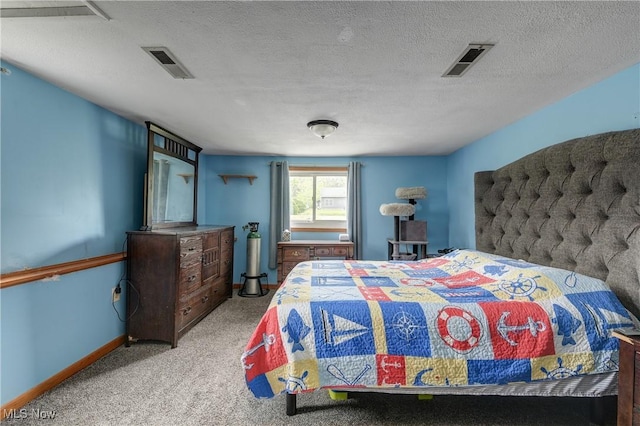 bedroom featuring carpet floors, baseboards, and a textured ceiling