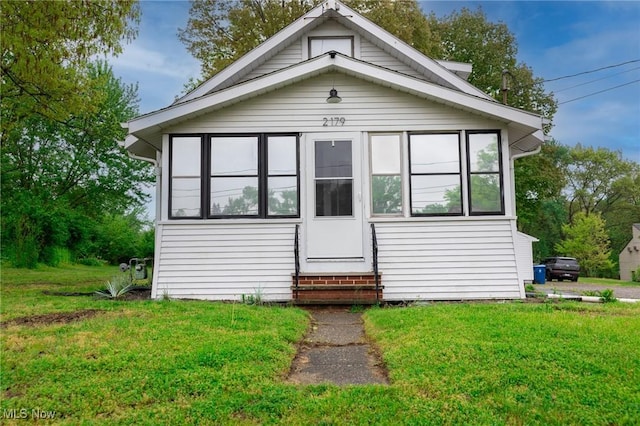 view of front of home with entry steps and a front yard