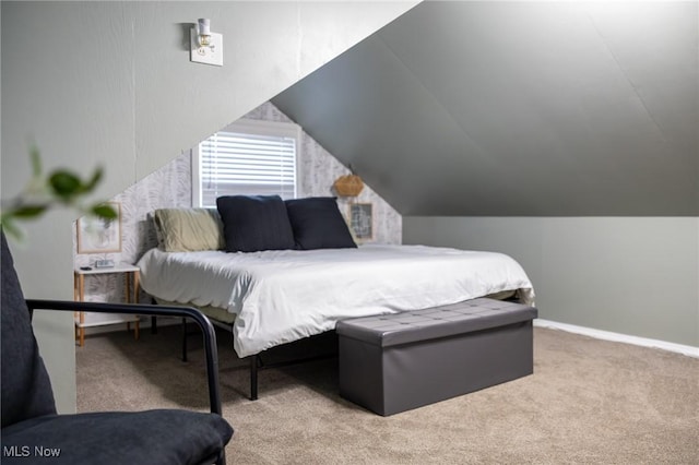 bedroom with carpet floors, vaulted ceiling, and baseboards