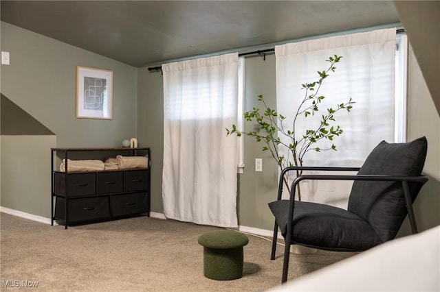 living area featuring carpet flooring, baseboards, and vaulted ceiling